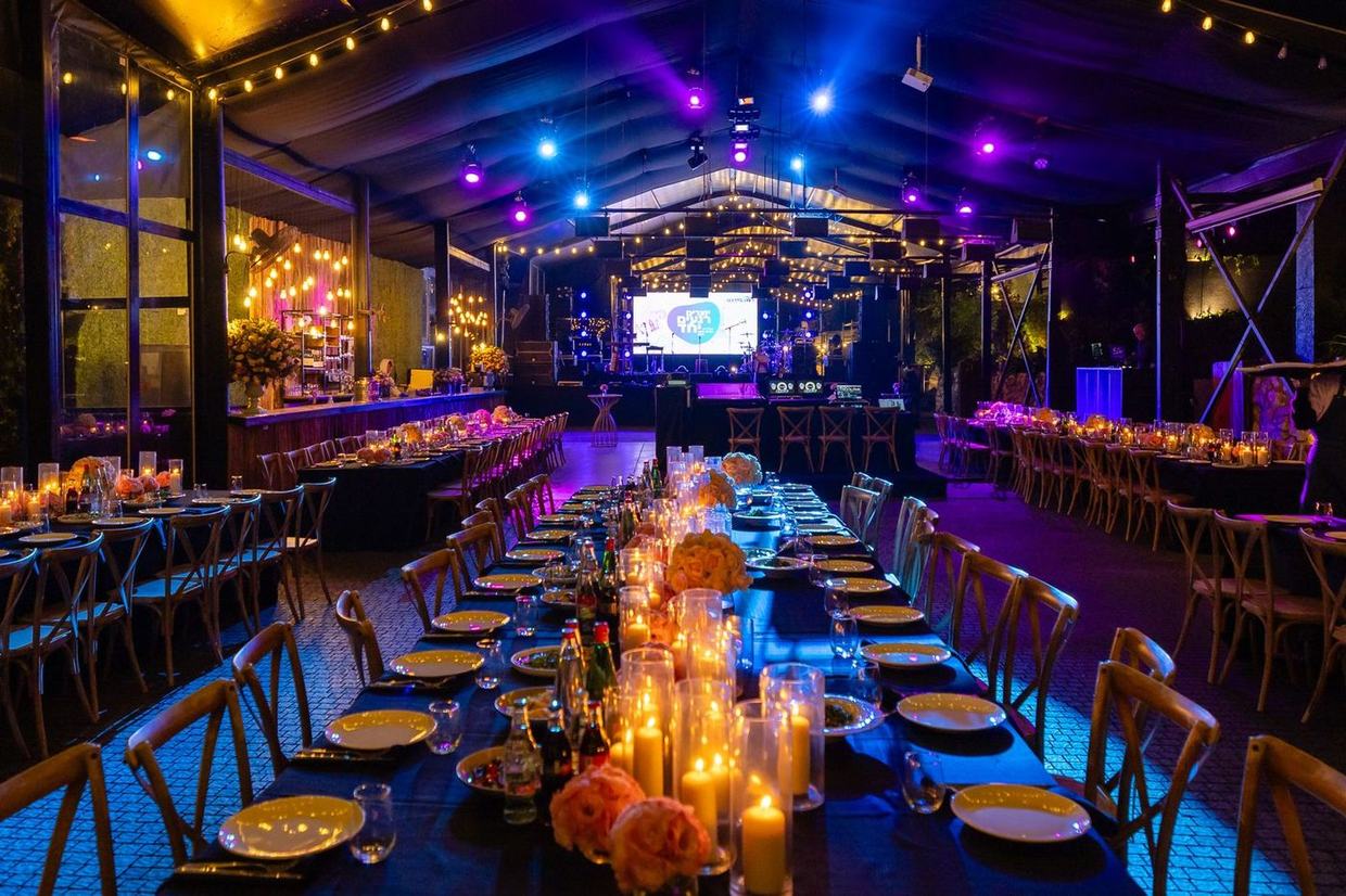 Long candlelit banquet tables set for an evening event